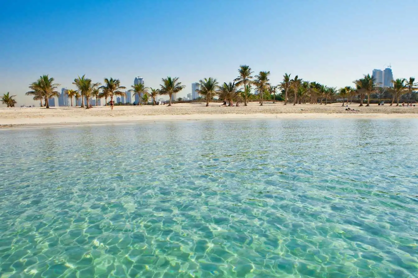 plage à Dubaï palmiers sur sable fin eau turquoise journée ensoleillée